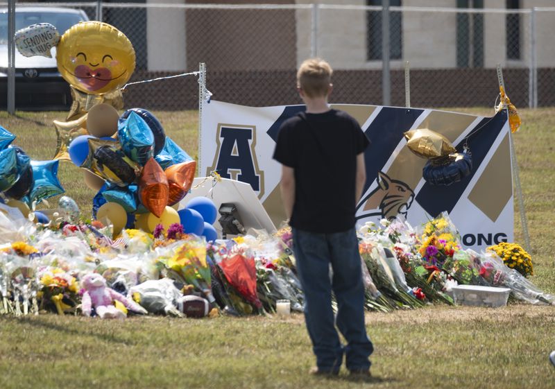 People visit a makeshift memorial in front of Apalachee High School in Winder on Saturday, Sept. 7, 2024.   (Ben Gray / Ben@BenGray.com)