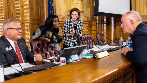 State Election Board Executive Director Mike Coan (from left) and members Janelle King, Janice Johnston and Rick Jeffares speak during a break during a board meeting at the Capitol in Atlanta on July 9. That meeting prompted a lawsuit alleging it had violated the Georgia Open Meetings Act. (Arvin Temkar/AJC 2024)