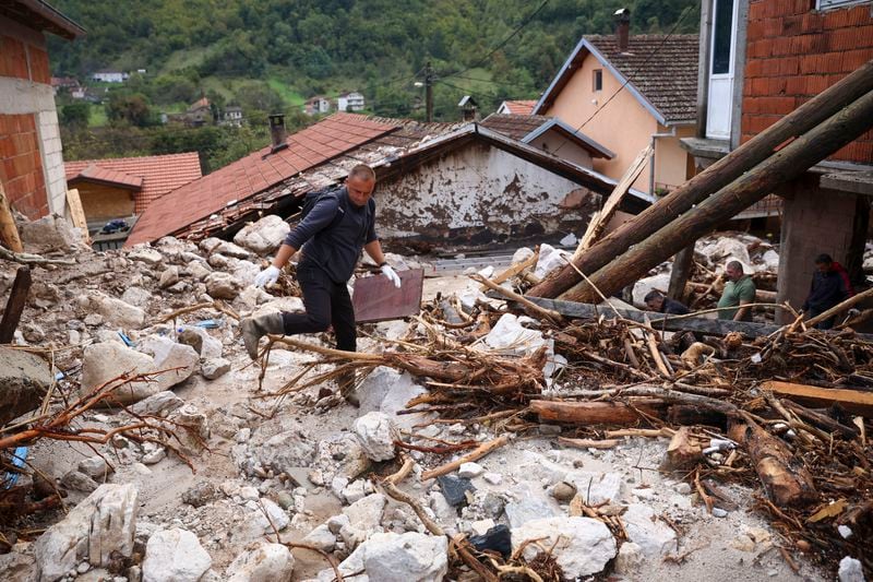 People inspect a damaged house after floods and landslides in the village of Donja Jablanica, Bosnia, Saturday, Oct. 5, 2024. (AP Photo/Armin Durgut)