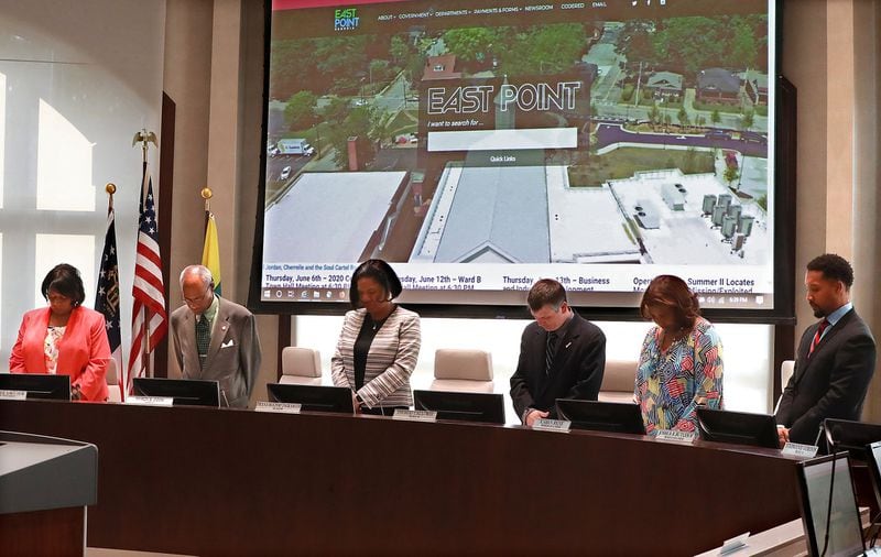 Nanette Saucier (from left), Myron Cook, Mayor Deana Holiday Ingraham, Thomas Calloway, Karen Rene, and Joshua B. Butler IV bow in prayer to open the East Point City Council meeting on Monday, June 3, 2019, in East Point. Curtis Compton/ccompton@ajc.com