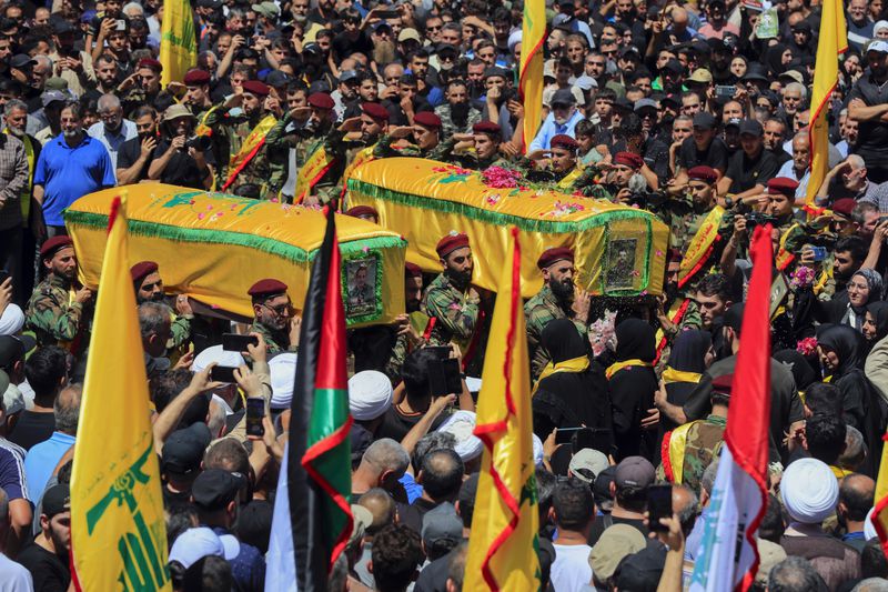 Mourners carry the coffins of Hezbollah fighters Mohammed Hussein Qassem and Abbas Ahmed Soror, who were killed by an Israeli strike, during their funeral procession in Aita al-Shaab village, south Lebanon, Saturday, June 29, 2024. (AP Photo/Mohammed Zaatari)