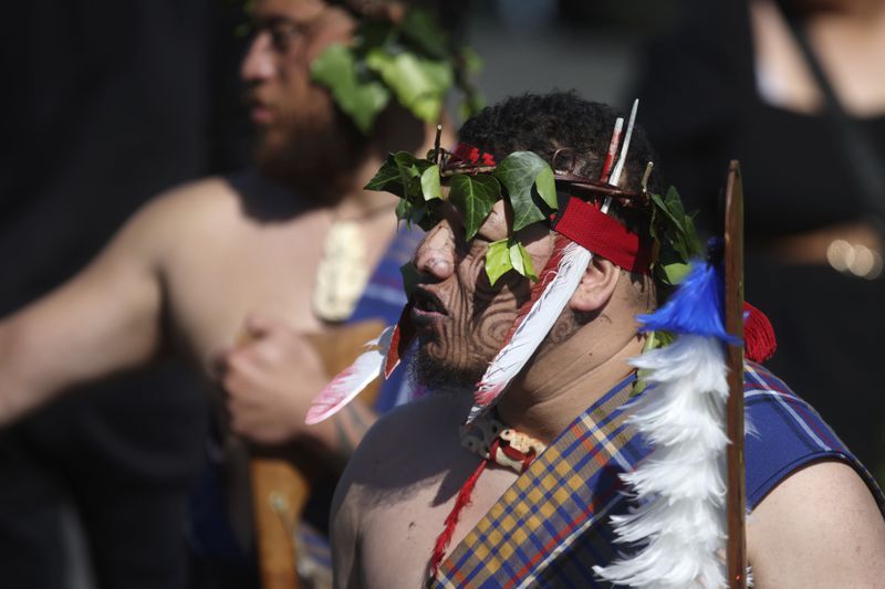 A warrior waits for the arrival of the coffin of New Zealand's Maori King, Kiingi Tuheitia Pootatau Te Wherowhero VII, before the burial in Ngaruawahia, New Zealand, Thursday, Sept. 5, 2024. (AP Photo/Alan Gibson)