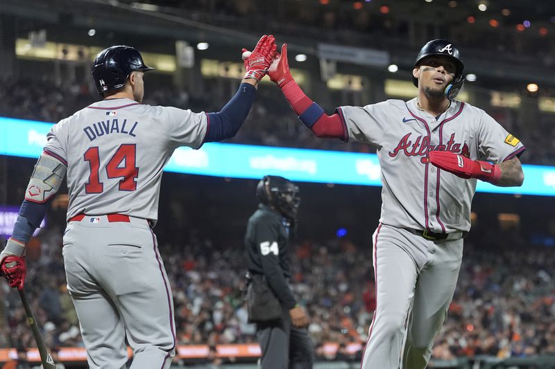 Atlanta Braves' Orlando Arcia, right, is congratulated by Adam Duvall (14) after scoring against the San Francisco Giants during the 10th inning of a baseball game in San Francisco, Monday, Aug. 12, 2024. (AP Photo/Jeff Chiu)