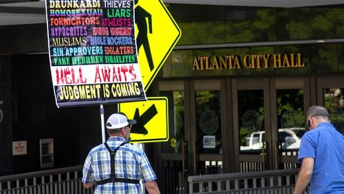 Kerrigan Skelly holds a protest sign outside Atlanta City Hall before Steven Igarashi-Ball, who performs drag as Miss Terra Cotta Sugarbaker, reads to a group of children at the Drag Queen Story Hour event at Atlanta City Hall on Saturday, June 29, 2019. Skelly has joined preachers who've spoken on some of Georgia's college campuses. (Steve Schaefer / AJC file photo)