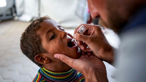 A health worker administers a polio vaccine to a child at a hospital in Deir al-Balah, central Gaza Strip, Sunday, Sept. 1, 2024. (AP Photo/Abdel Kareem Hana)