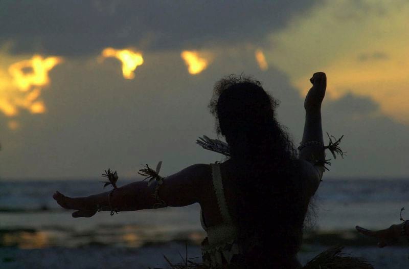 FILE - A Kiribati dancer raises her arms as she welcomes the first sunrise of the new year on Millennium Island, Kiribati, on Jan. 1, 2000. (AP Photo/Katsumi Kasahara, File)