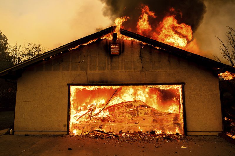 Flames consume a garage as the Thompson Fire burns in Oroville, Calif., Tuesday, July 2, 2024. An extended heatwave blanketing Northern California has resulted in red flag fire warnings and power shutoffs. (AP Photo/Noah Berger)