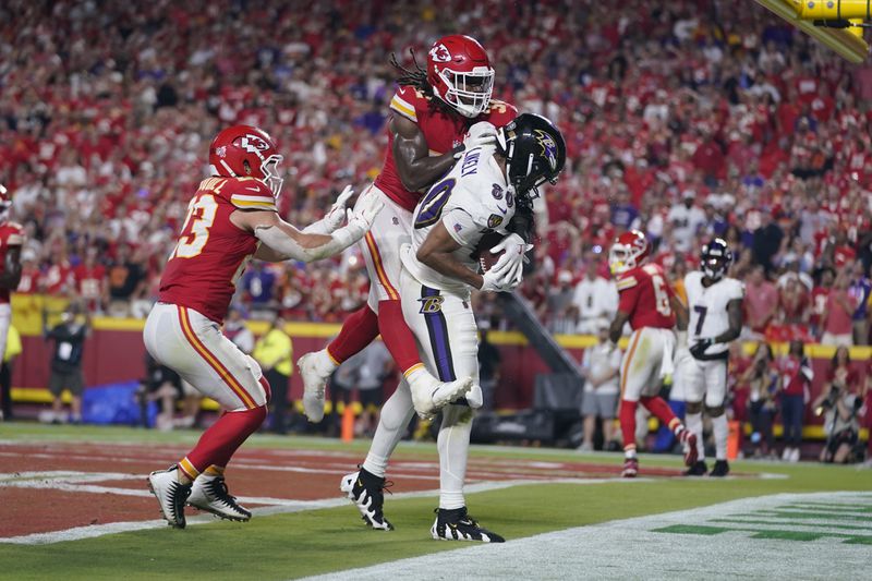 Baltimore Ravens tight end Isaiah Likely, left, catches a pass with his toe out of bounds as Kansas City Chiefs linebacker Nick Bolton (32) and linebacker Drue Tranquill (23) defend as time time expires in the second half of an NFL football game Thursday, Sept. 5, 2024, in Kansas City, Mo. The Chiefs won 27-20.(AP Photo/Ed Zurga)