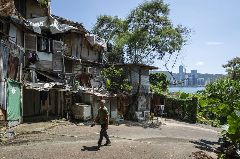 A villager walks through the Cha Kwo Ling village in east Kowloon, Hong Kong, Sunday, Aug. 25, 2024. (AP Photo/Chan Long Hei)