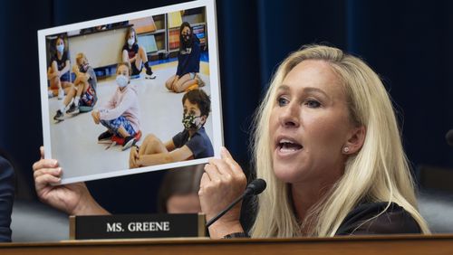 U.S. Rep. Marjorie Taylor Greene, R-Rome, holds up a photo during a congressional subcommittee hearing on the coronavirus pandemic in Washington on Monday.
