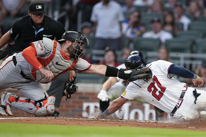 San Francisco Giants catcher Curt Casali (18) tags out Atlanta Braves' Austin Riley (27) in the fifth inning of a baseball game, Wednesday, July 3, 2024, in Atlanta. (AP Photo/Brynn Anderson)