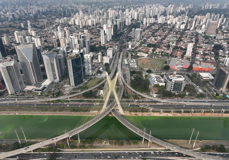 The Pinheiros River is green in Sao Paulo, Brazil, Tuesday, Sept. 10, 2024. The state's environmental authority attributes the river's new green hue to an algae bloom, the result of severe drought that has significantly lowered water levels. (AP Photo/Andre Penner)