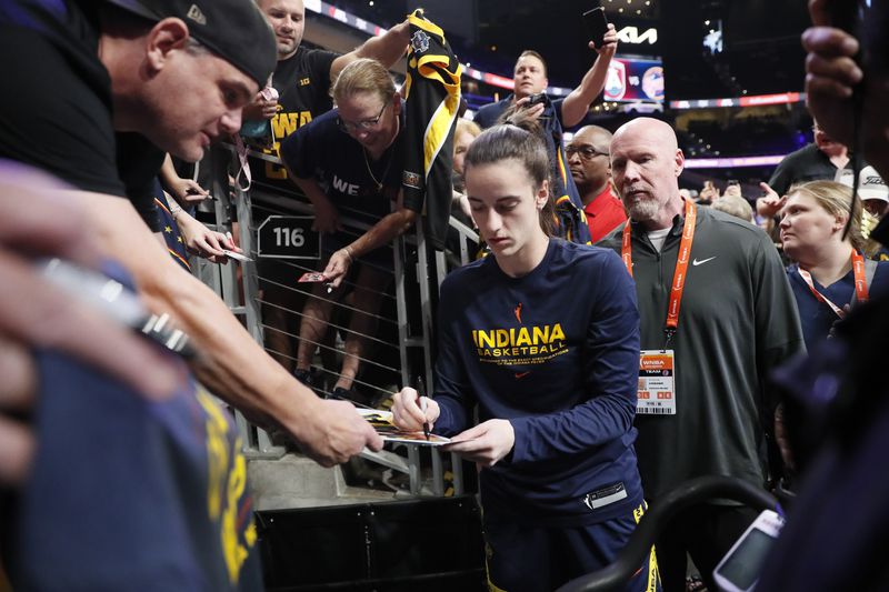 Indiana Fever guard Caitlin Clark signs autographs before taking on the Dream at State Farm Arena.