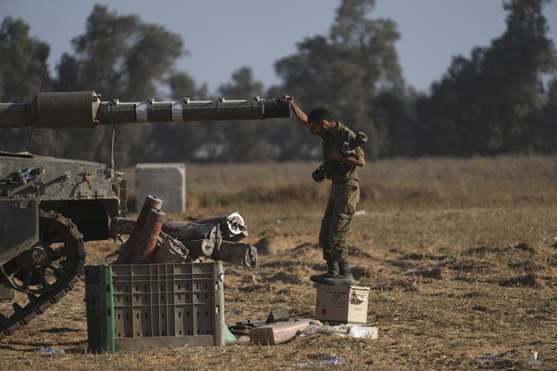 An Israeli soldier works on a tank near the Gaza border in southern Israel, Friday, May 24, 2024. (AP Photo/Tsafrir Abayov)