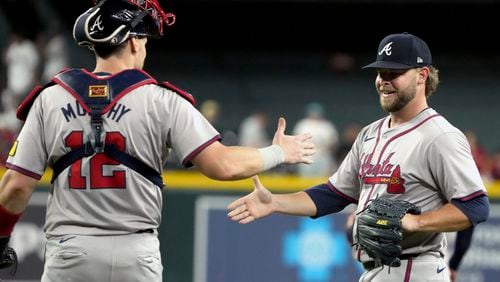 Atlanta Braves catcher Sean Murphy (12) and pitcher A.J. Minter celebrate after defeating the Arizona Diamondbacks in a baseball game Tuesday, July 9, 2024, in Phoenix. (AP Photo/Rick Scuteri)