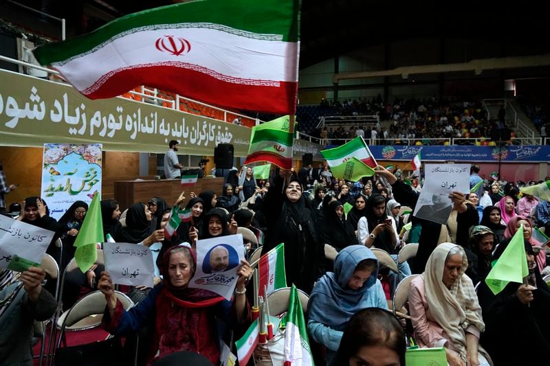 Supporters of Mohammad Bagher Qalibaf, the most prominent candidate for the June 28, presidential election, who is Iran's parliament speaker, wave the country's flags during his campaign rally in Tehran, Iran, Tuesday, June 18, 2024. (AP Photo/Vahid Salemi)