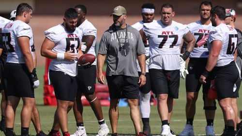 Falcons offensive line coach Dwayne Ledford (center) starts a drill with guard Chris Lindstrom (63, left), center Matt Hennessy (61, with ball), tackle Jalen Mayfield (77), tackle Jake Matthews and center Drew Dalman (67, right) during training camp. (Jason Getz / Jason.Getz@ajc.com)