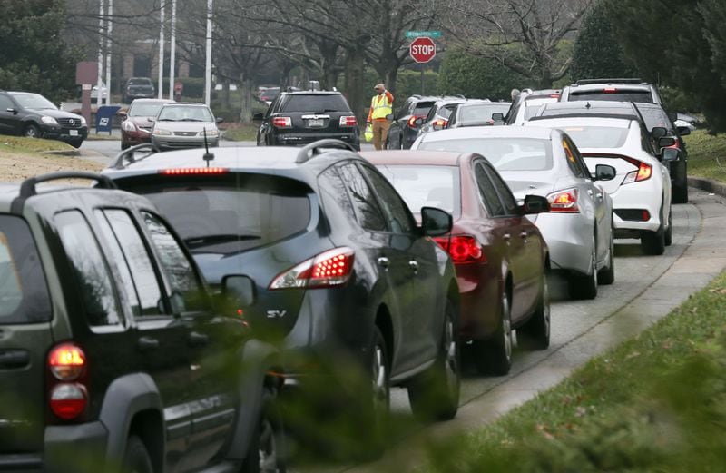 Cars stretched in a line back to the interstate, as federal employees wait for their turn to pick up food. Bob Andres / bandres@ajc.com