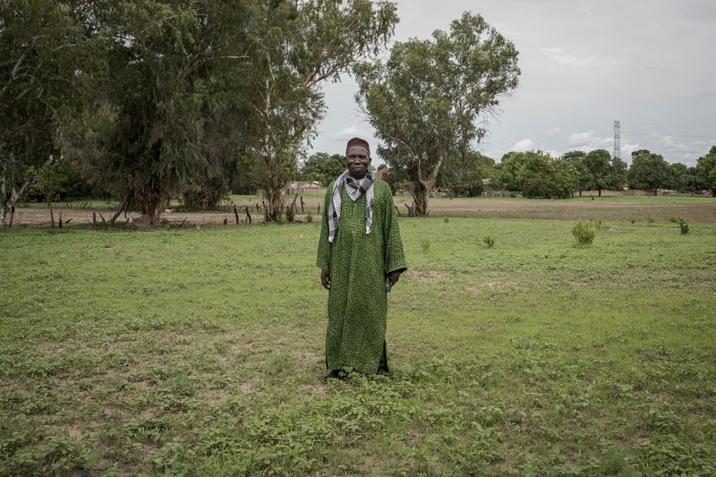 Ansumana Sanneh, whose son migrated to Russia, poses for a portrait on his farm in Kwinella village, Gambia, on July 27, 2024. (AP Photo/Annika Hammerschlag)