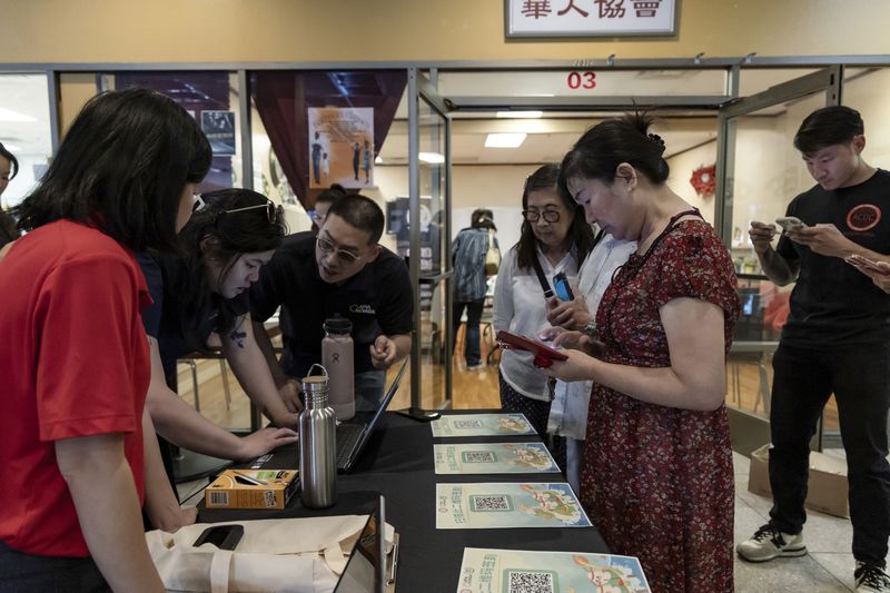 Members of the Las Vegas Asian community receive information on how to vote in Chinese during the annual Dragon Boat Festival in Las Vegas, Wednesday, June 5, 2024. Advocates are working to help non-English speakers access voting materials in their primary language. (Christopher Lomahquahu/News21 via AP)