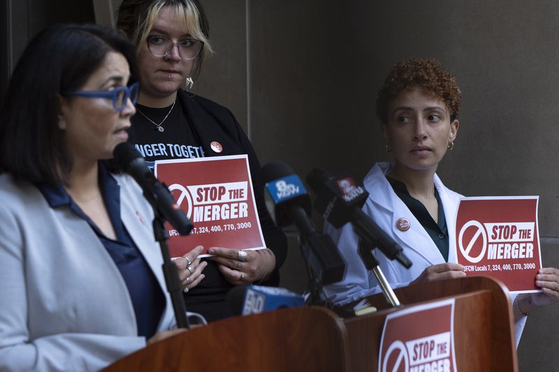 Kim Cordova, President UFCW 7, left, speaks about the Kroger and Albertsons merger during a news conference outside the federal courthouse before a hearing on the merger on Monday, Aug. 26, 2024, in Portland, Ore. Rickee Nelson, UFCW Local 7 member and grocery store worker, center, and Jessi Crowley, a pharmacist at Albertsons-owned Pavilions, right, listen. (AP Photo/Jenny Kane)