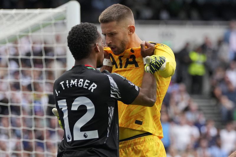 Arsenal's Jurrien Timber and Tottenham's goalkeeper Guglielmo Vicario square-up to each other during the English Premier League soccer match between Tottenham Hotspur and Arsenal in London, Sunday, Sept. 15, 2024. (AP Photo/Kin Cheung)