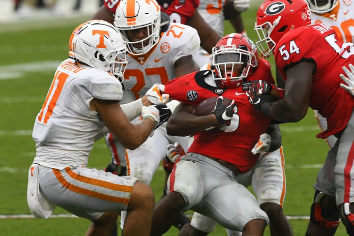 Georgia running back Zamir White is grabbed by Tennessee linebacker Henry To'o To’o, left, during the second half of a football game Saturday, Oct. 10, 2020, at Sanford Stadium in Athens. Georgia won 44-21. JOHN AMIS FOR THE ATLANTA JOURNAL- CONSTITUTION