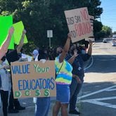 Protesters hold signs outside the DeKalb County School District's Stone Mountain headquarters on July 23, 2020. (Marlon A. Walker / AJC file photo)