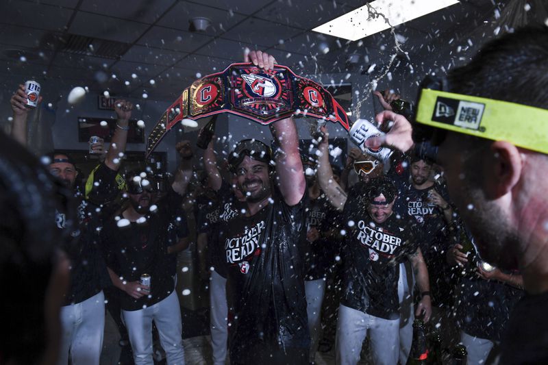 The Cleveland Guardians celebrate in the clubhouse after they defeated the Minnesota Twins to clinch a baseball playoff berth, Thursday, Sept. 19, 2024, in Cleveland. (AP Photo/Nick Cammett)