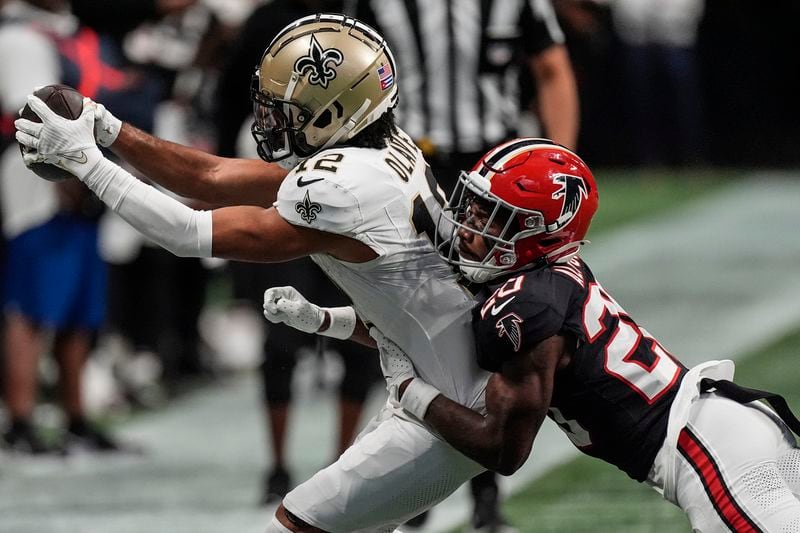 New Orleans Saints wide receiver Chris Olave (12) makes a catch against Atlanta Falcons cornerback Dee Alford (20) during the second half of an NFL football game, Sunday, Sept. 29, 2024, in Atlanta. (AP Photo/John Bazemore)