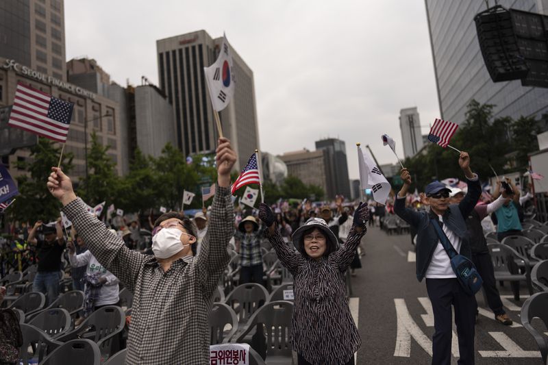 Members of a right-wing group supporting the U.S., wave South Korean and American flags while chanting slogans during a rally near the U.S. Embassy in Seoul, Saturday, May 25, 2024. (AP Photo/Jae C. Hong)