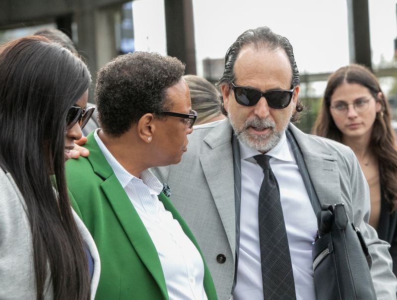 Rev Mitzi Bickers (green blazer) is found guilty on all but three charges at the Richard B Russell Federal Courthouse on Wednesday, March 23, 2022.  Bickers is surrounded by friends, family and her attorney Drew Findling (dark sunglasses) as she leaves the courthouse.  Sentencing is scheduled for July 12.  (Jenni Girtman for The Atlanta Journal-Constitution) 