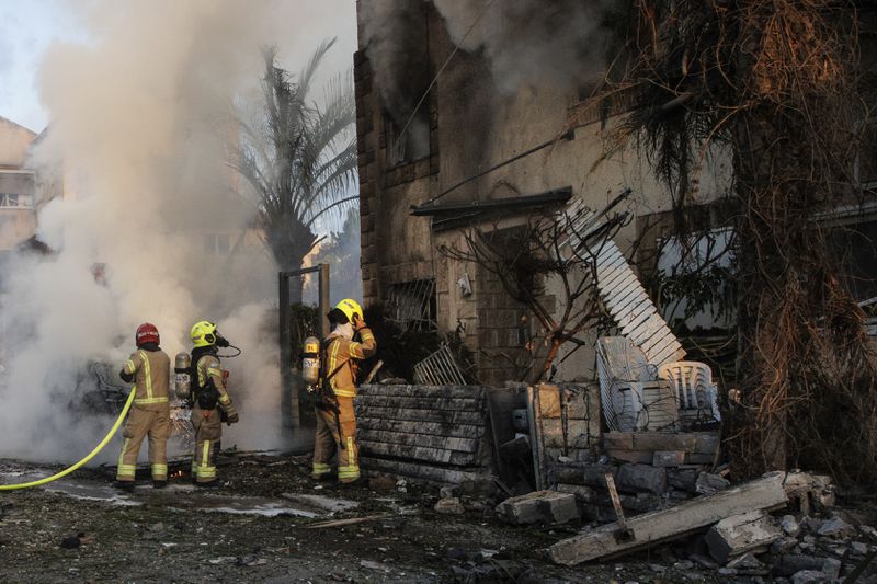 Israeli security and rescue forces work at the site hit by a rocket fired from Lebanon, in Kiryat Bialik, northern Israel, on Sunday, Sept. 22, 2024. (AP Photo/Gil Nechushtan)