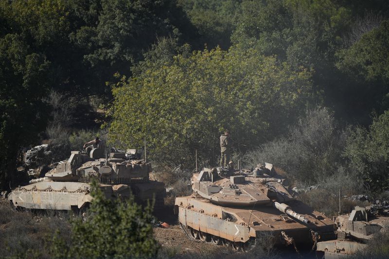 Israeli soldiers work on tanks in northern Israel on Friday, Sept. 27, 2024. (AP Photo/Baz Ratner)