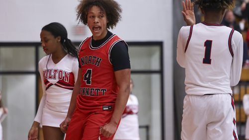 North Gwinnett guard Caleb Jones-Dicks (4) celebrates a play against Milton forward Anthony Gause (1) during the first half of their first round of the boys’ Class 7A playoffs at Milton High School, Wednesday, February 21, 2024, in Milton, Ga. Milton won 67-54. (Jason Getz / jason.getz@ajc.com)