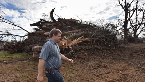 South Georgia pecan farmer Trey Pippin walks past a pile of dead pecan trees at his farm in Albany in 2019. South Georgia farmers will get some federal disaster relief aid for the estimated $2.5 billion in losses from Hurricane Michael. HYOSUB SHIN / HSHIN@AJC.COM