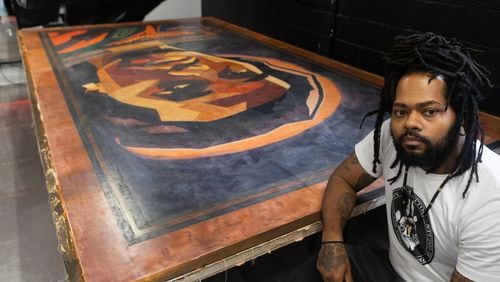 Tattoo artist J.R. Outlaw poses for a portrait after Guinness World Records officially announced his art piece is the worlds largest tattoo which is of the late rapper Takeoff at Atlanta Ink in Atlanta on July 5, 2023. J.R. spent several months on the tattoo, with the help of others. (Michael Blackshire/Michael.blackshire@ajc.com)