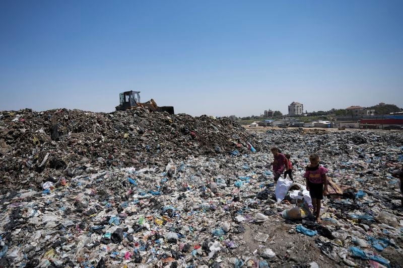 FILE - Palestinians sort through trash at a landfill in Nuseirat refugee camp, Gaza Strip, Thursday, June 20, 2024. Health authorities and aid agencies are racing to avert an outbreak of polio in the Gaza Strip after the virus was detected in the territory's wastewater and three cases with a suspected polio symptom have been reported. (AP Photo/Abdel Kareem Hana, File)