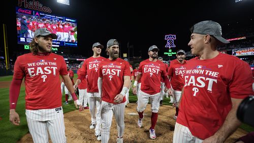 Philadelphia Phillies' Alec Bohm, from left, Jeff Hoffman, Bryce Harper, Kyle Schwarber, Garrett Stubbs and J.T. Realmuto celebrate after winning a baseball game against the Chicago Cubs to clinch the NL East title, Monday, Sept. 23, 2024, in Philadelphia. (AP Photo/Matt Slocum)