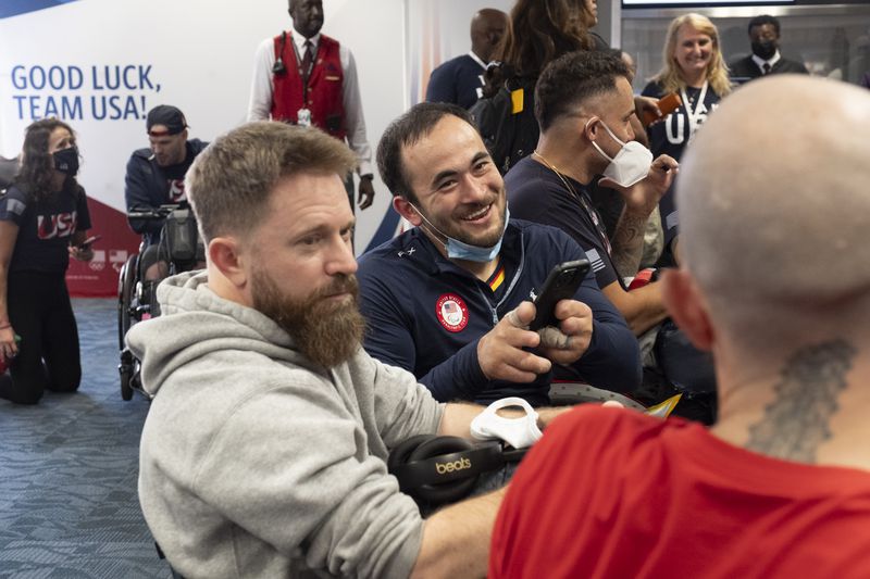 Chuck Aoki shoots videos of his fellow USA Paralympic wheelchair rugby team members as they prepare to board a Delta flight from Atlanta to Paris on Tuesday, Aug. 20, 2024. (Ben Gray / Ben@BenGray.com)