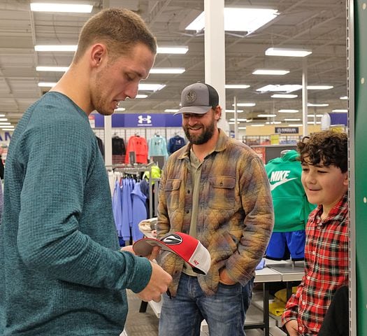 Fans stop Carson Beck in the store for autographs and photos while he was there shopping with the Athens area Boys and Girls club children. UGA Quarterback Carson Beck was on site at an Athen Academy store Sunday December 17, 2023, to give out gift cards to lucky members of area Boys and Girls Clubs. Academy Sports and Outdoors contributed $200 for each child and he kicked in $135 more of his own money to help families out. 

credit: Nell Carroll for the AJC