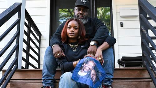 Reggie Cunningham, top, and his wife Ferguson activist Brittany Packnett-Cunningham pose for an image while holding a handkerchief with picture of her father Rev. Ronald Packnett and Brittany, Saturday, Sep. 7, 2024, in Mount Rainier, Md. (AP Photo/Terrance Williams)