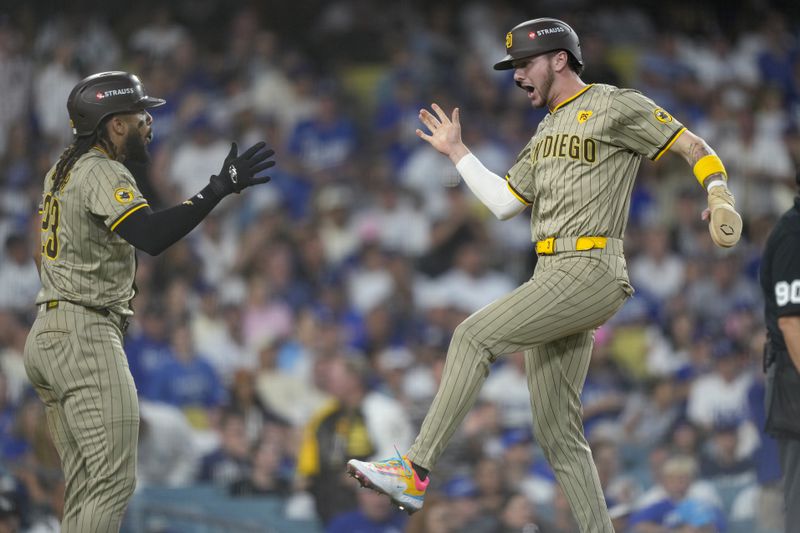 San Diego Padres' Jackson Merrill, right, celebrates with Fernando Tatis Jr. after they both scored on a two-run double hit by Xander Bogaerts during the third inning in Game 1 of baseball's NL Division Series against the Los Angeles Dodgers, Saturday, Oct. 5, 2024, in Los Angeles. (AP Photo/Mark J. Terrill)