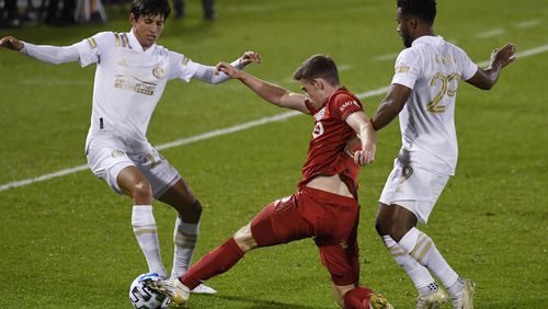 Atlanta United's Jurgen Damm (left) and  Mo Adams (right) challenge Toronto FC's Tony Gallacher during the first half Sunday, Oct. 18, 2020, in East Hartford, Conn. Toronto won 1-0. (Jessica Hill/AP)