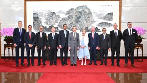 In this photo released by Xinhua News Agency, Chinese Foreign Minister Wang Yi, sixth from left, poses for a photo with a United States business delegation including FedEx CEO Raj Subramaniam, fifth from left, and Chindex CEO Roberta Lipson, fifth from right in Beijing on Monday, July 22, 2024. Chinese officials tell the visiting delegation of top U.S. executives that higher tariffs on imports from China will harm their businesses inside the country, as authorities double down on state secrets regulations at the same time the ruling Communist Party is vowing to improve the business environment for foreign investors. (Yue Yuewei/Xinhua via AP)