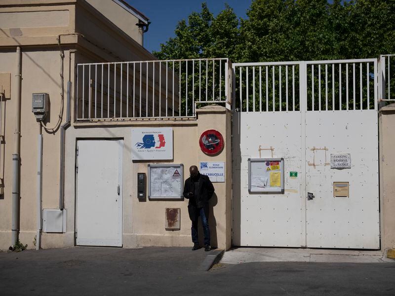 A man stands outside of the La Cabucelle school, a public in elementary school in Marseille, southern France, Monday, April 22, 2024. (AP Photo/Daniel Cole)