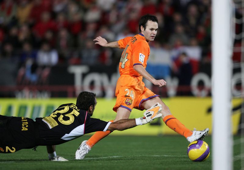 FILE - Barcelona's Andres Iniesta, right, scores against RCD Mallorca goalkeeper Antoni Prats during their Spanish League soccer match at Son Moix Stadium in the Balearic island of Mallorca, Spain, on Nov. 19, 2006. Andres Iniesta who scored Spain's World Cup-winning goal in 2010 and was one of the key players who made Barcelona's tiki-taka thrive for so long, announced his retirement from soccer on Tuesday. (AP Photo/Bernat Armangue, File)