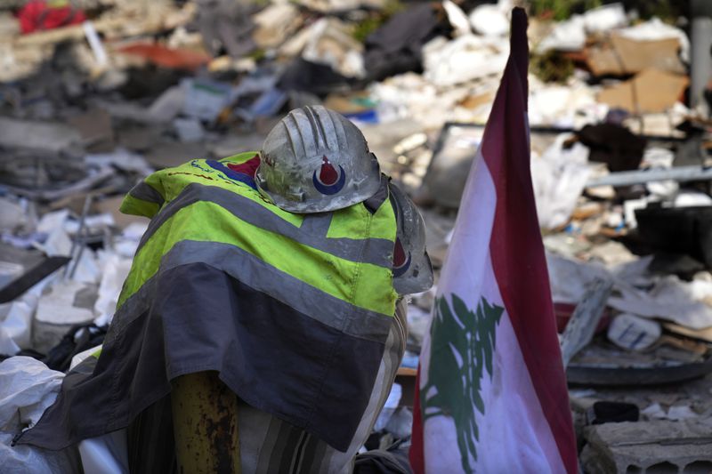 Hezbollah paramedic stuff left on the debris after an airstrike hit an apartment in a multistory building, in central Beirut, Lebanon, Thursday, Oct. 3, 2024. (AP Photo/Hussein Malla)