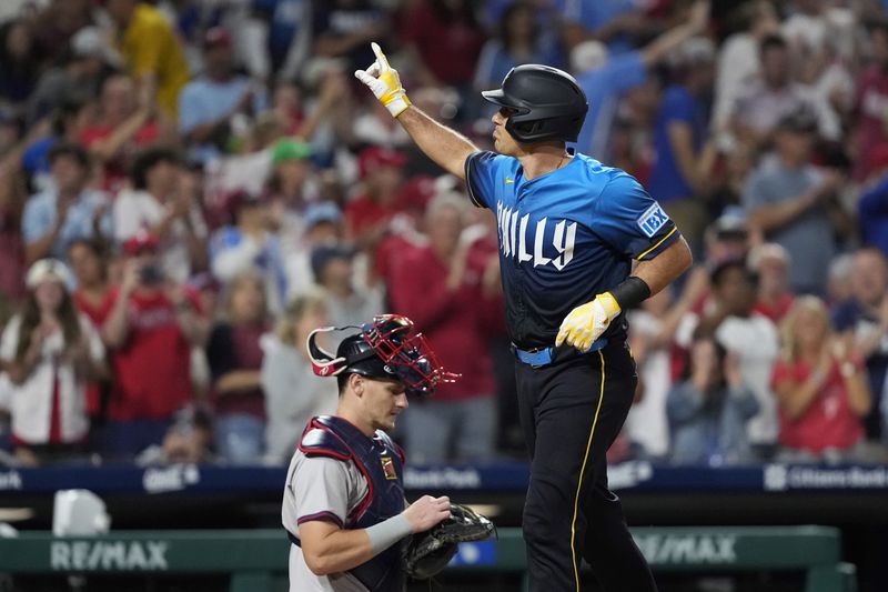 Philadelphia Phillies' J.T. Realmuto, right, reacts after hitting a home run against Atlanta Braves pitcher Pierce Johnson during the seventh inning of a baseball game, Friday, Aug. 30, 2024, in Philadelphia. (AP Photo/Matt Slocum)