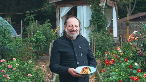 Executive chef and owner Mark Henegan of the Bush Farmhouse poses in the restaurant's garden with a bowl of his South African-inspired hoppin' John. (Grace Dickinson for The Atlanta Journal-Constitution)